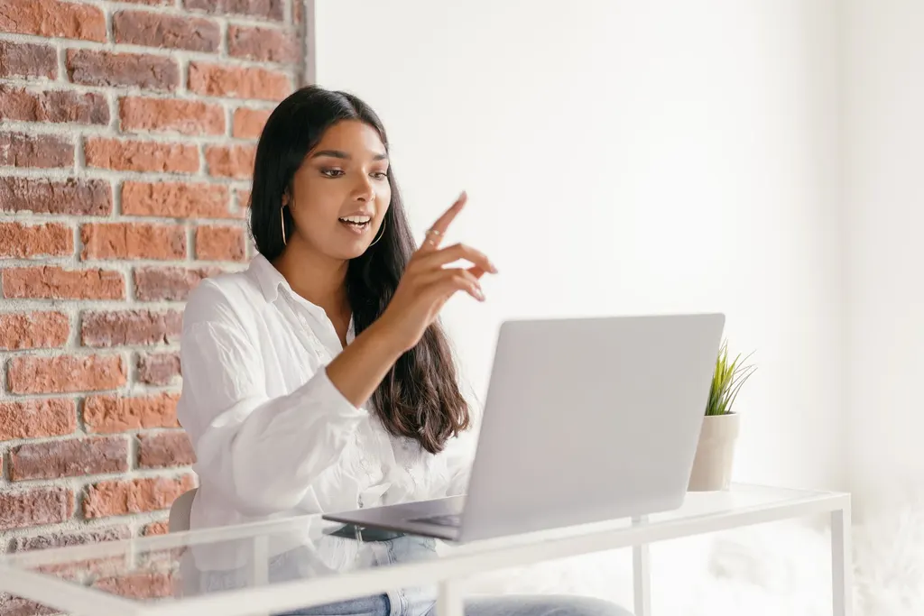 Profesional latina revisando desempeño en pantalla durante trabajo remoto